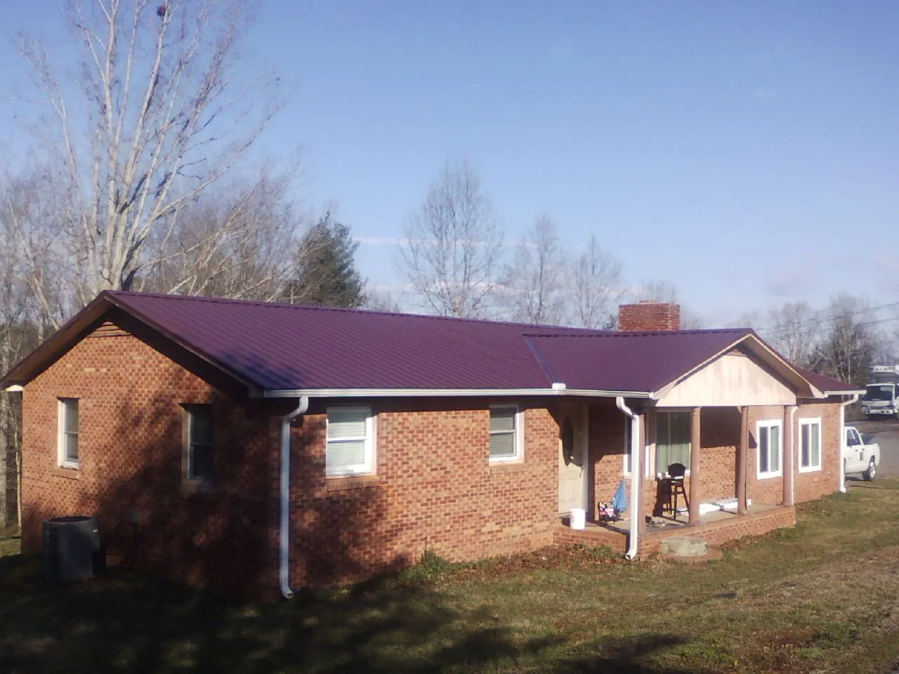 Burgundy metal roof on a brick ranch home with a new addition in Melrose